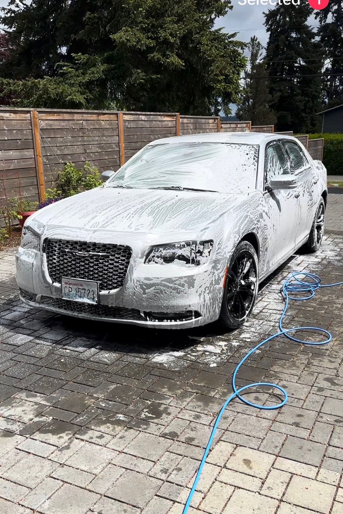 Sedan covered in thick foam during an exterior wash